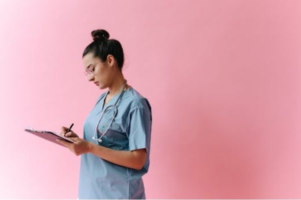 A doctor carefully taking notes to prepare a sick leave note for a patient.