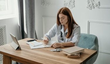 Doctor writing a note in a notebook to support a patient's sick leave needs.